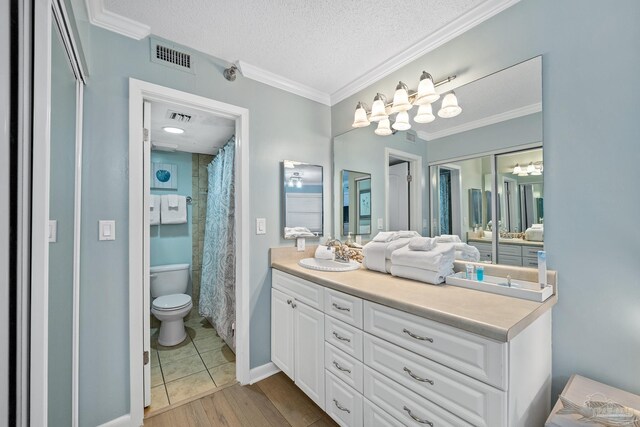 bathroom featuring hardwood / wood-style floors, toilet, vanity, and a textured ceiling