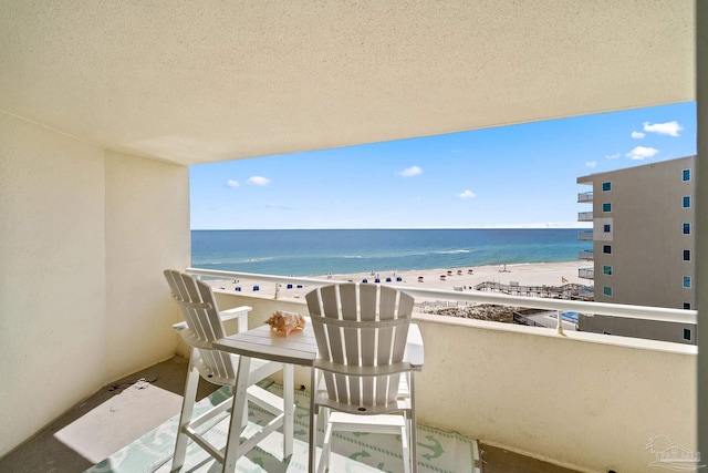 balcony featuring a water view and a beach view