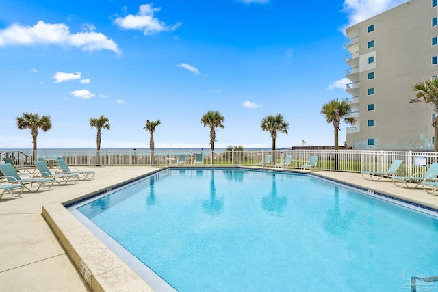 view of pool with a patio and a water view