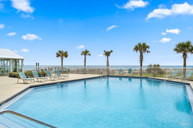 view of pool featuring a water view and a patio area