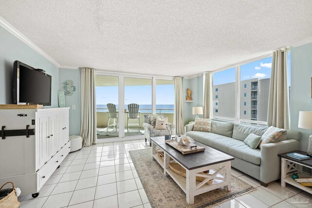 living room featuring light tile patterned floors, a water view, a textured ceiling, and crown molding