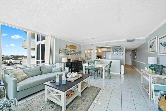 living room featuring an inviting chandelier, crown molding, a textured ceiling, and light tile patterned floors