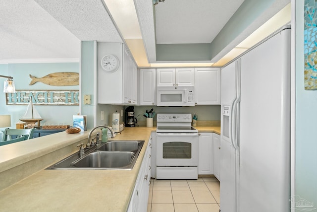 kitchen featuring white cabinetry, sink, light tile patterned floors, and white appliances