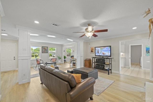 living room with visible vents, ceiling fan, decorative columns, and crown molding