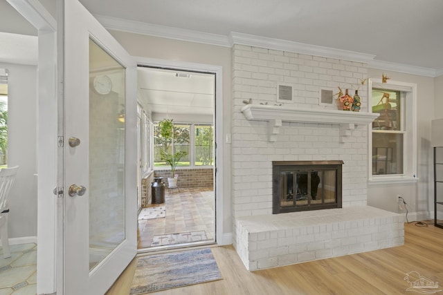 bathroom with visible vents, wood finished floors, a fireplace, and crown molding