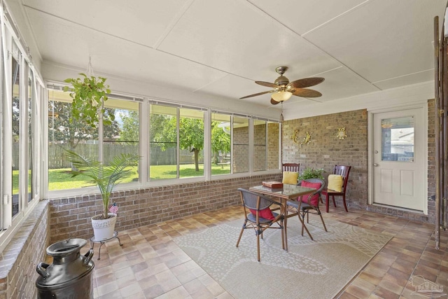 sunroom / solarium with outdoor dining area, ceiling fan, and a healthy amount of sunlight