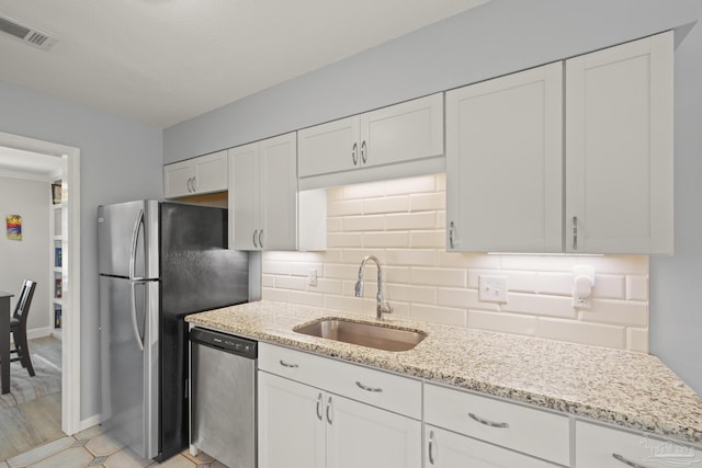 kitchen featuring a sink, decorative backsplash, visible vents, white cabinets, and appliances with stainless steel finishes