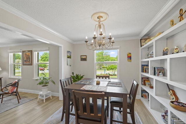 dining area with a textured ceiling, light wood-style floors, plenty of natural light, and a notable chandelier