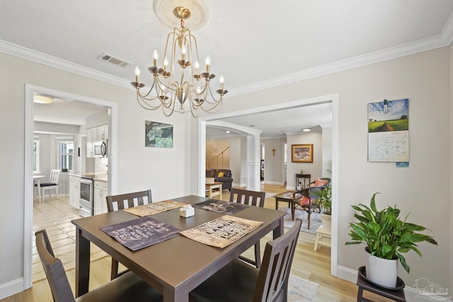 dining space with light wood-style flooring, a chandelier, ornamental molding, baseboards, and visible vents