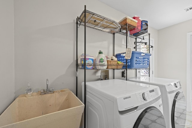 laundry room with washer and clothes dryer, visible vents, laundry area, and a sink