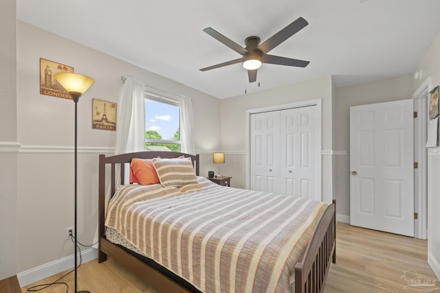 bedroom featuring light wood finished floors, a closet, a ceiling fan, and baseboards