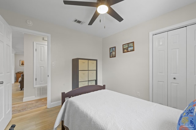 bedroom with visible vents, baseboards, a closet, light wood-type flooring, and a ceiling fan