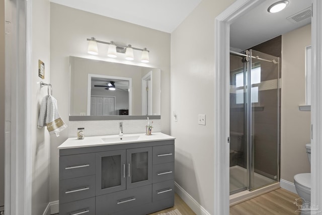 bathroom with toilet, visible vents, a shower stall, and wood finished floors