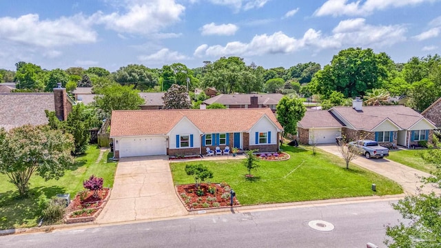 view of front of property featuring a front lawn, driveway, an attached garage, and brick siding
