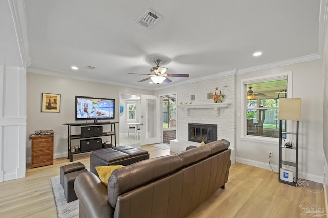 living area featuring light wood finished floors, a ceiling fan, visible vents, and baseboards