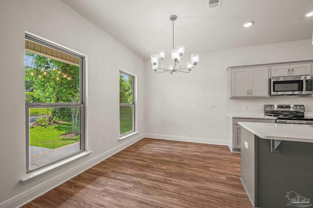 520 K St, Pensacola, FL 32501 - kitchen with stainless steel appliances, light countertops, gray cabinets, a chandelier, and hanging light fixtures