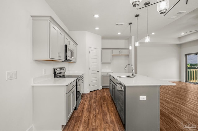 520 K St, Pensacola, FL 32501 - kitchen with stainless steel appliances, a sink, gray cabinets, dark wood-style floors, and light countertops