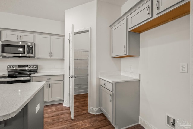 520 K St, Pensacola, FL 32501 - kitchen featuring stainless steel appliances, gray cabinetry, dark wood-style floors, baseboards, and light stone countertops