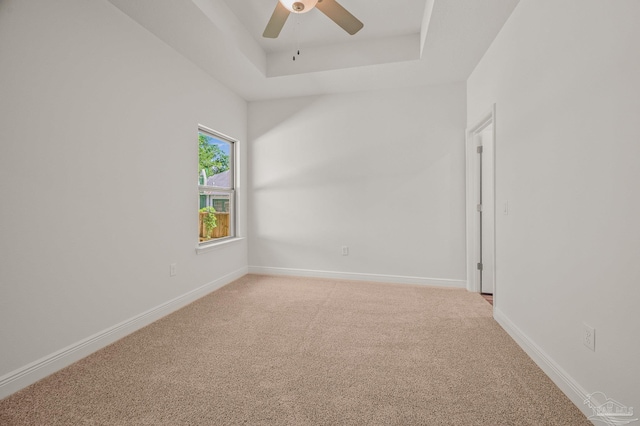 520 K St, Pensacola, FL 32501 - empty room featuring a tray ceiling, a ceiling fan, light carpet, and baseboards
