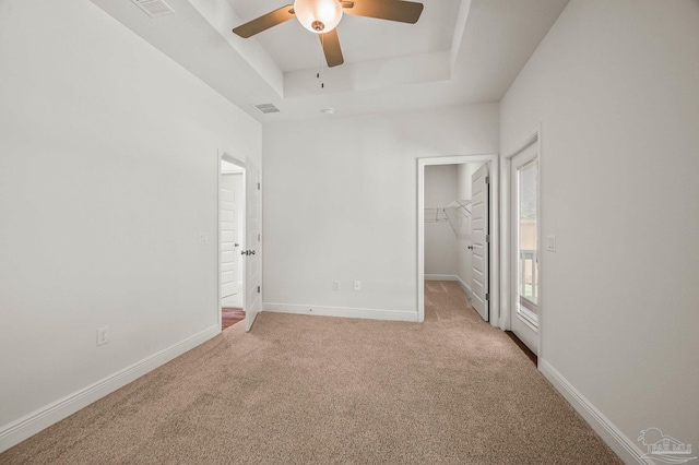 520 K St, Pensacola, FL 32501 - unfurnished bedroom with a spacious closet, light colored carpet, a tray ceiling, and baseboards