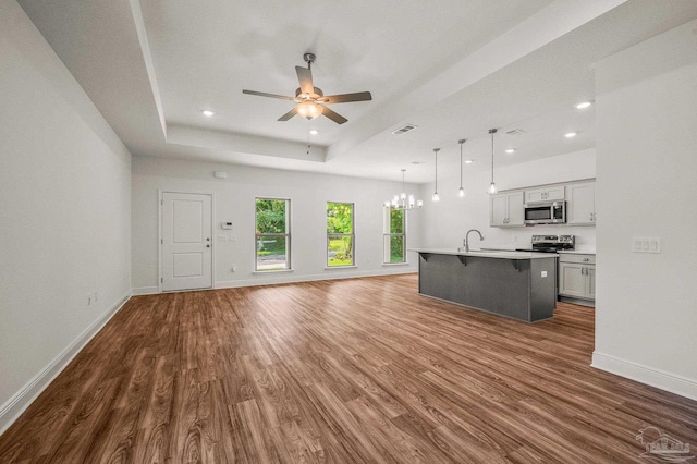 520 K St, Pensacola, FL 32501 - unfurnished living room with a tray ceiling, dark wood-type flooring, ceiling fan, recessed lighting, and baseboards