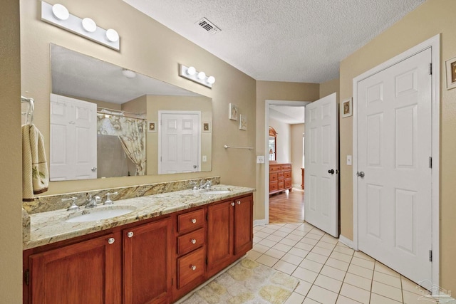 bathroom with curtained shower, vanity, a textured ceiling, and hardwood / wood-style flooring