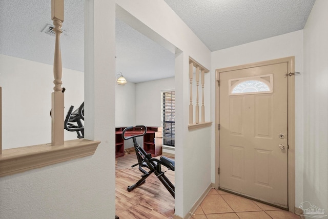 foyer featuring light hardwood / wood-style floors and a textured ceiling