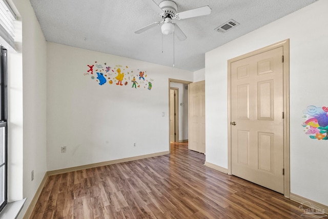 unfurnished bedroom with hardwood / wood-style floors, ceiling fan, and a textured ceiling