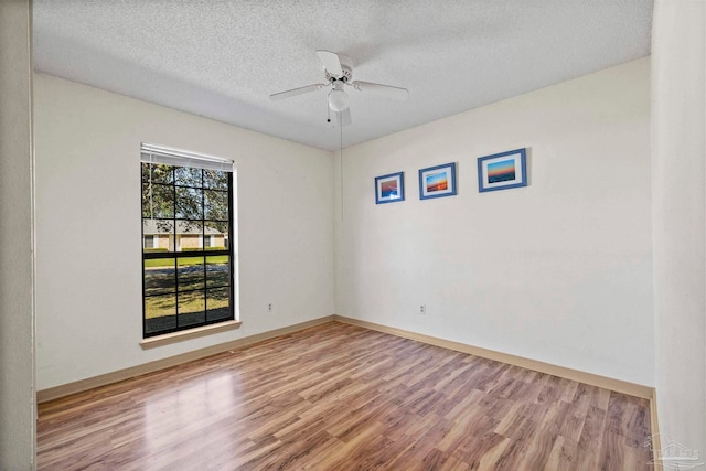 empty room featuring ceiling fan, hardwood / wood-style floors, and a textured ceiling