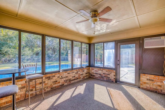 unfurnished sunroom featuring a wall unit AC and ceiling fan