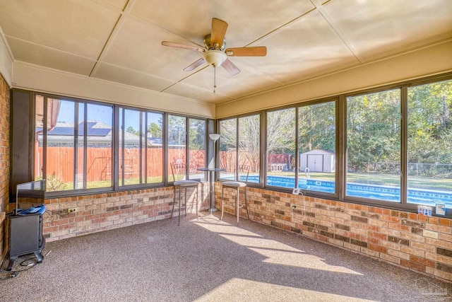 unfurnished sunroom featuring ceiling fan and a healthy amount of sunlight