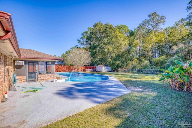 view of pool featuring a lawn, a patio area, and a storage shed