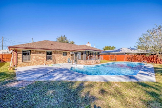 view of pool featuring a lawn and a patio