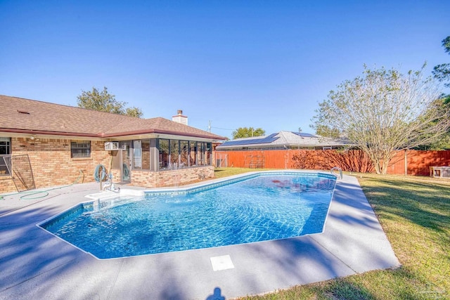 view of pool with a wall mounted air conditioner, a yard, and a patio area