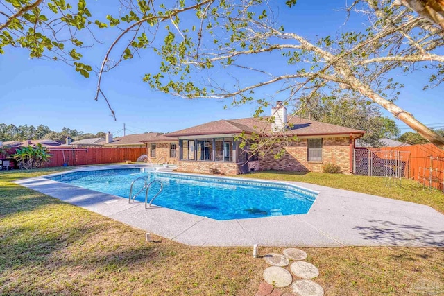 view of swimming pool with a lawn