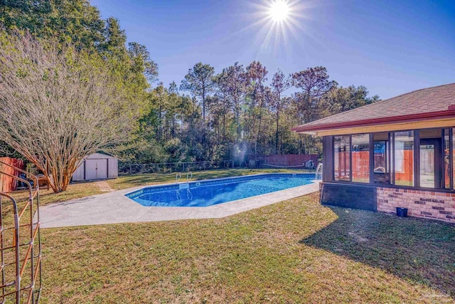 view of swimming pool featuring a lawn and a storage shed