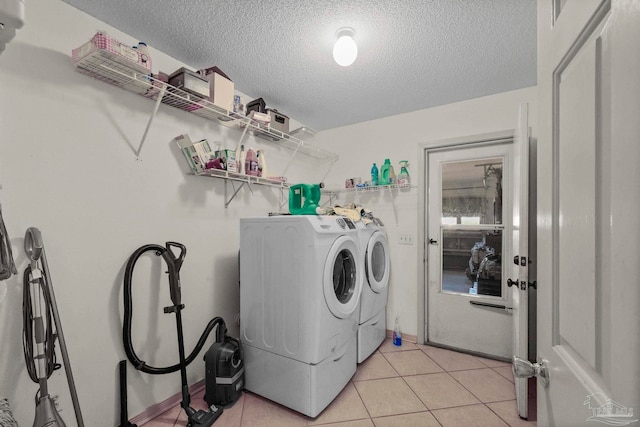 laundry area featuring independent washer and dryer, a textured ceiling, and light tile patterned flooring