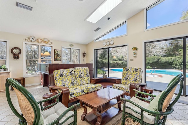 living room featuring light tile patterned floors, a skylight, visible vents, and a healthy amount of sunlight