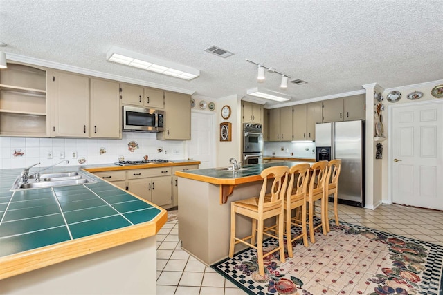 kitchen featuring stainless steel appliances, a sink, visible vents, open shelves, and an island with sink