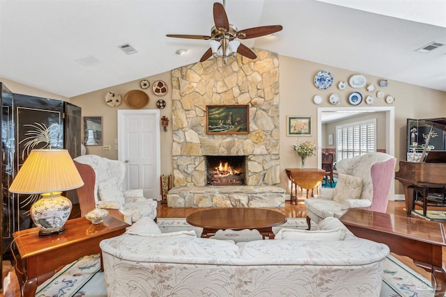 living room with lofted ceiling, a stone fireplace, and visible vents