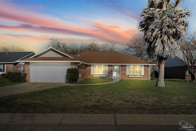 single story home with concrete driveway, a yard, brick siding, and an attached garage