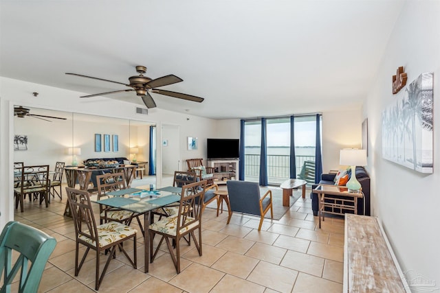 dining area with ceiling fan and a wall of windows