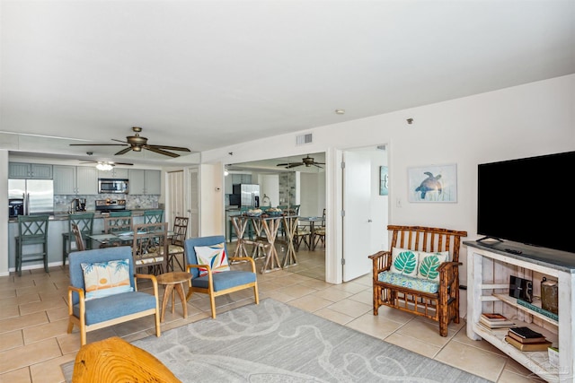 tiled living room with ceiling fan