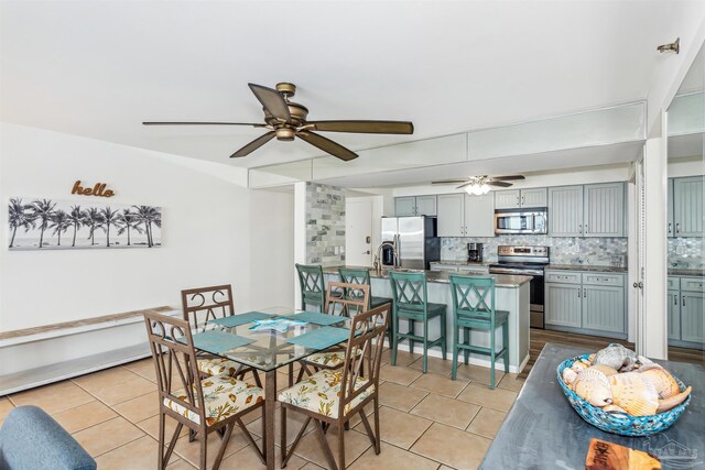 tiled dining space featuring ceiling fan