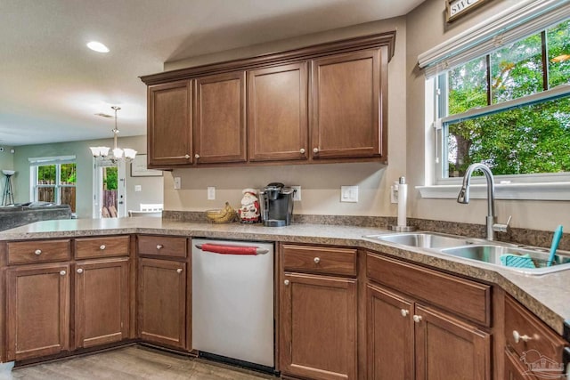 kitchen with stainless steel dishwasher, a notable chandelier, sink, and a wealth of natural light