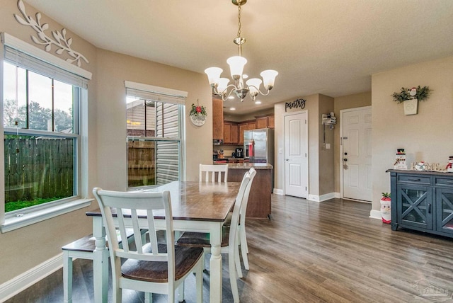 dining area featuring a textured ceiling, dark hardwood / wood-style floors, and a notable chandelier