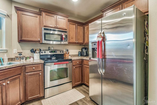 kitchen featuring sink, light wood-type flooring, and appliances with stainless steel finishes