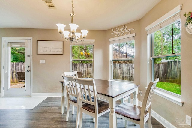 dining room with plenty of natural light, dark hardwood / wood-style floors, and a chandelier