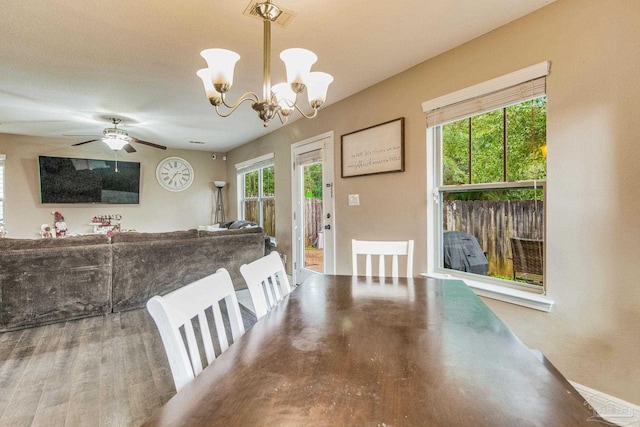 dining space with ceiling fan with notable chandelier