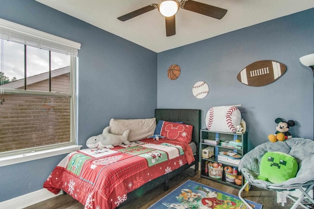 bedroom with dark hardwood / wood-style flooring and ceiling fan